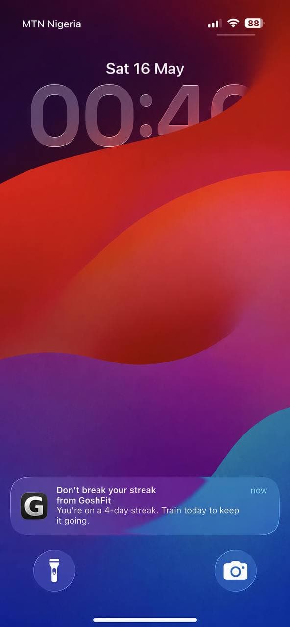iPhone lock screen with a GoshFit streak-at-risk push notification